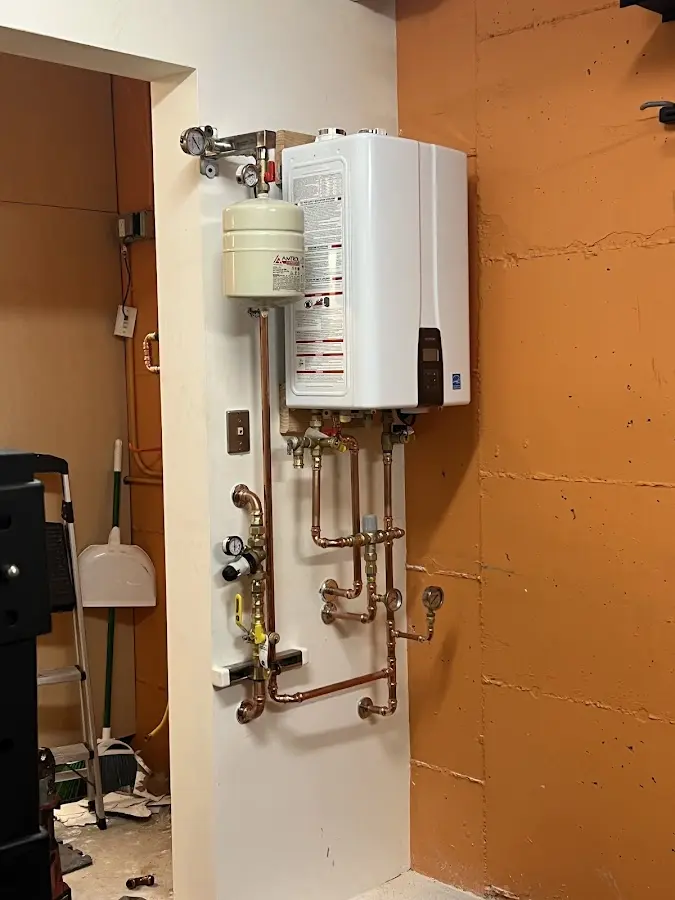 Plumbing technician inspecting water heater connections in La Riviera